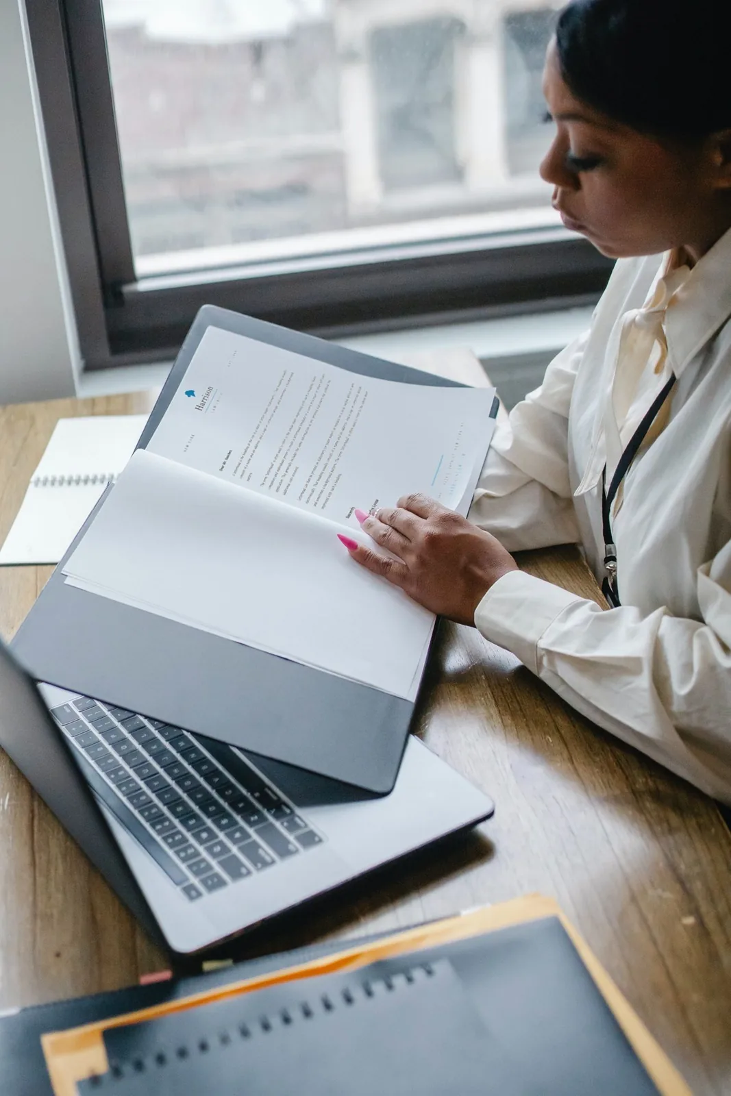 Consultant reviewing paperwork at a laptop